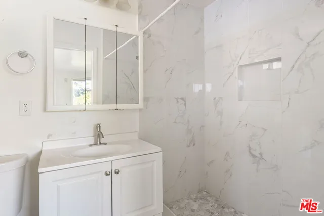 a bathroom with a sink a toilet and a mirror