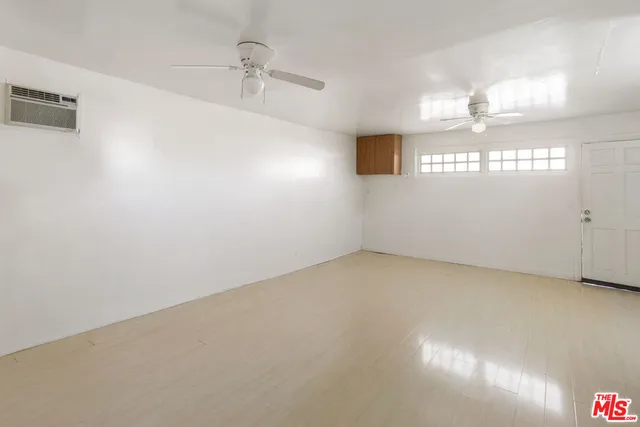 a view of a room with a stylish ceiling fan and entryway