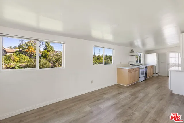 a view of a kitchen with wooden floor and a window