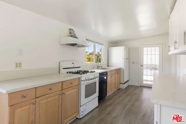 a kitchen with stainless steel appliances white cabinets and wooden floors