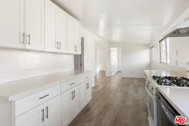 a kitchen with white cabinets and a stove