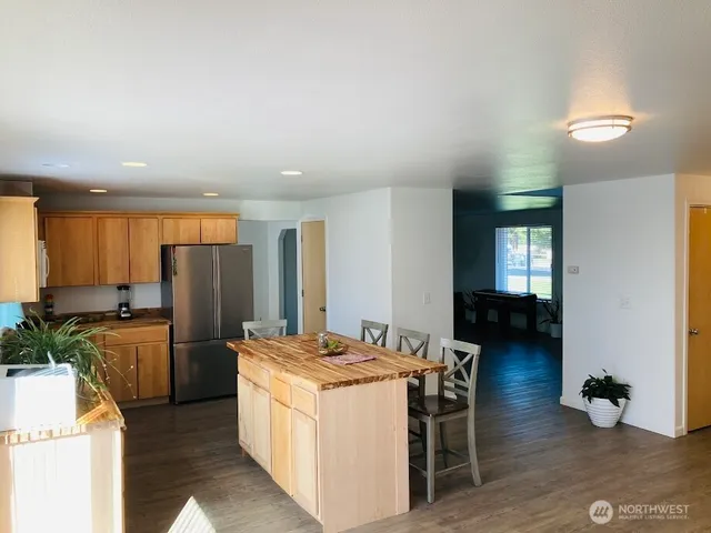 a kitchen that has a lot of cabinets a sink and a wooden floor