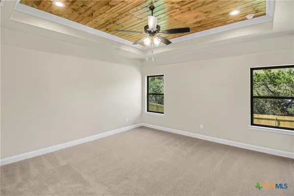 en empty room with windows and ceiling fan