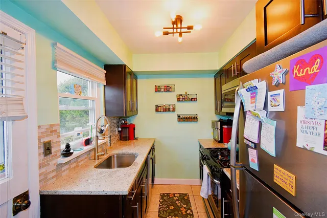 a view of a kitchen with fridge and window