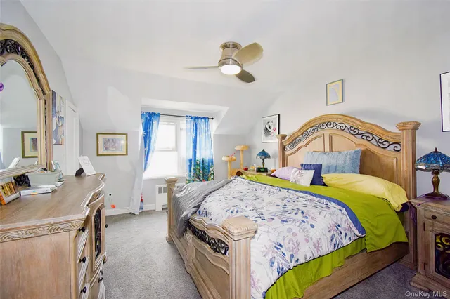 a bedroom with a bed a dresser and window