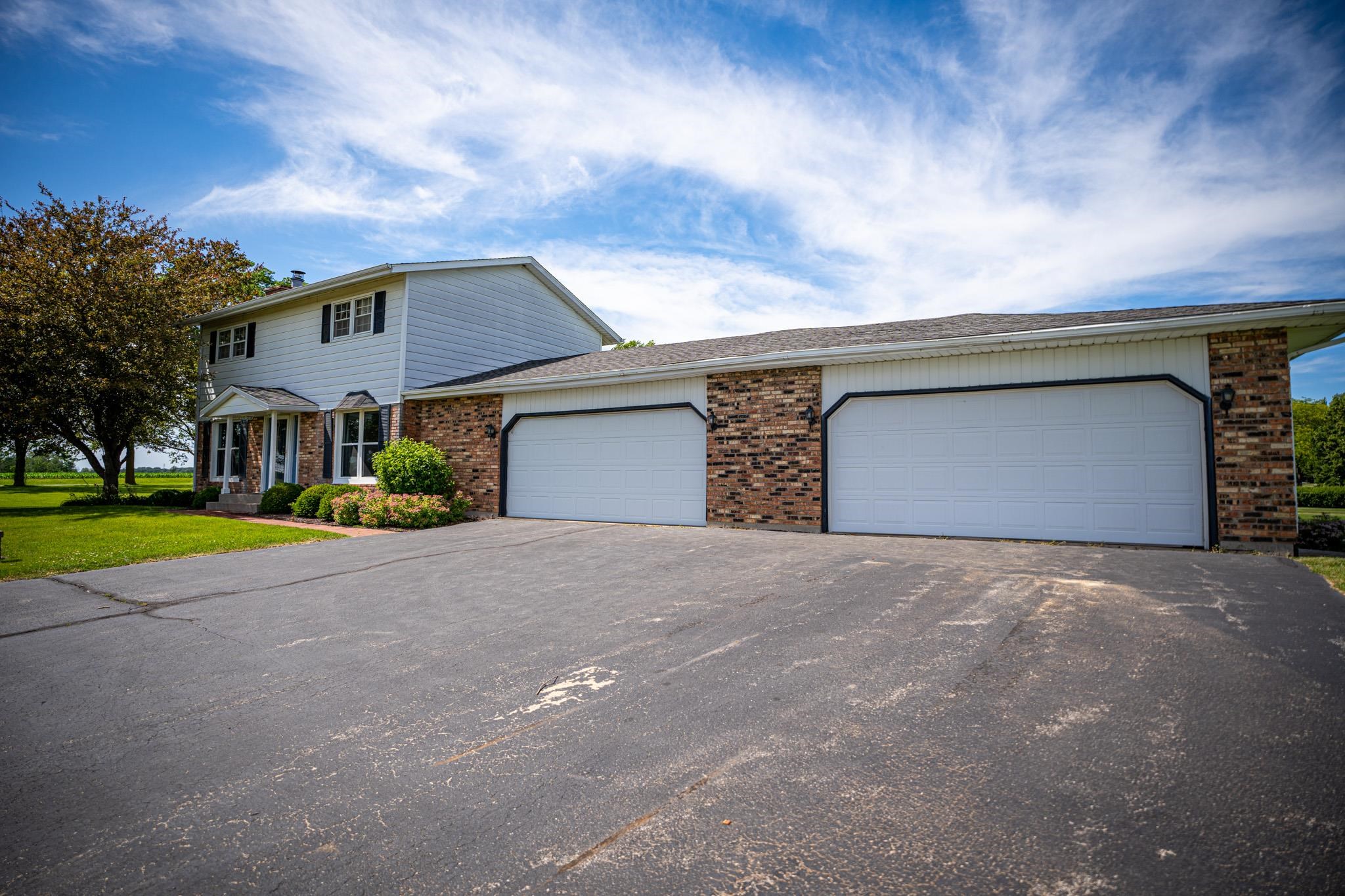 9092 East Scott Road Stillman Valley, IL 61084 - Photo 5 of 47 a front view of a house with a yard and garage