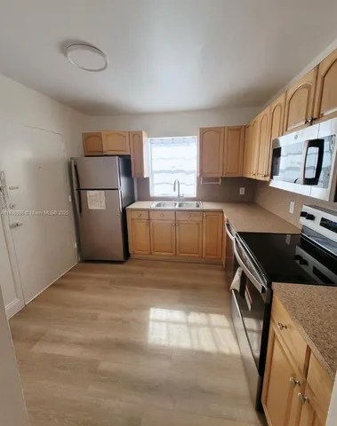 a kitchen with a sink a stove and a refrigerator