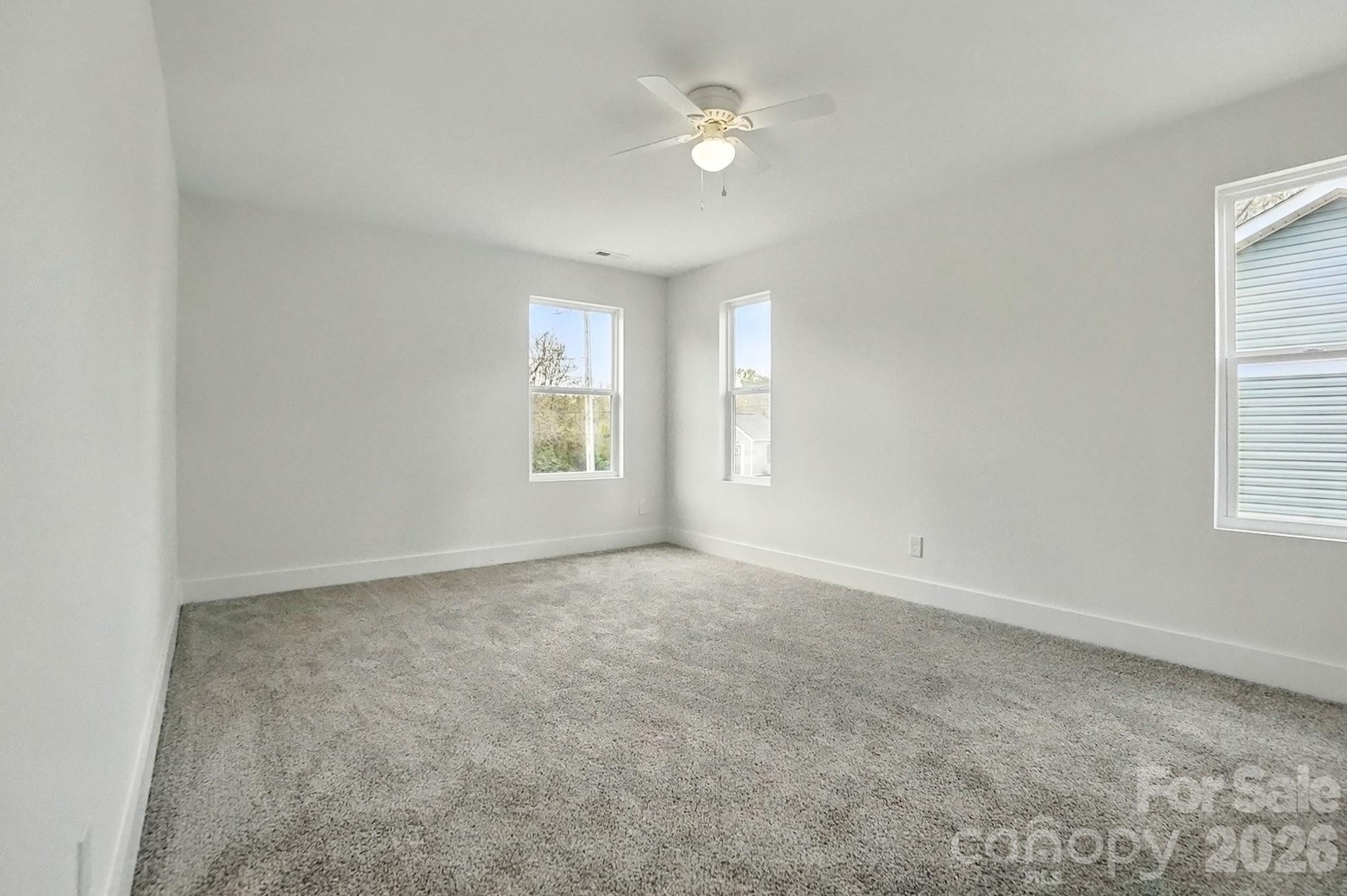 274 Bellhaven Place Northwest Concord, NC 28027 - Photo 15 of 27 an empty room with windows and ceiling fan