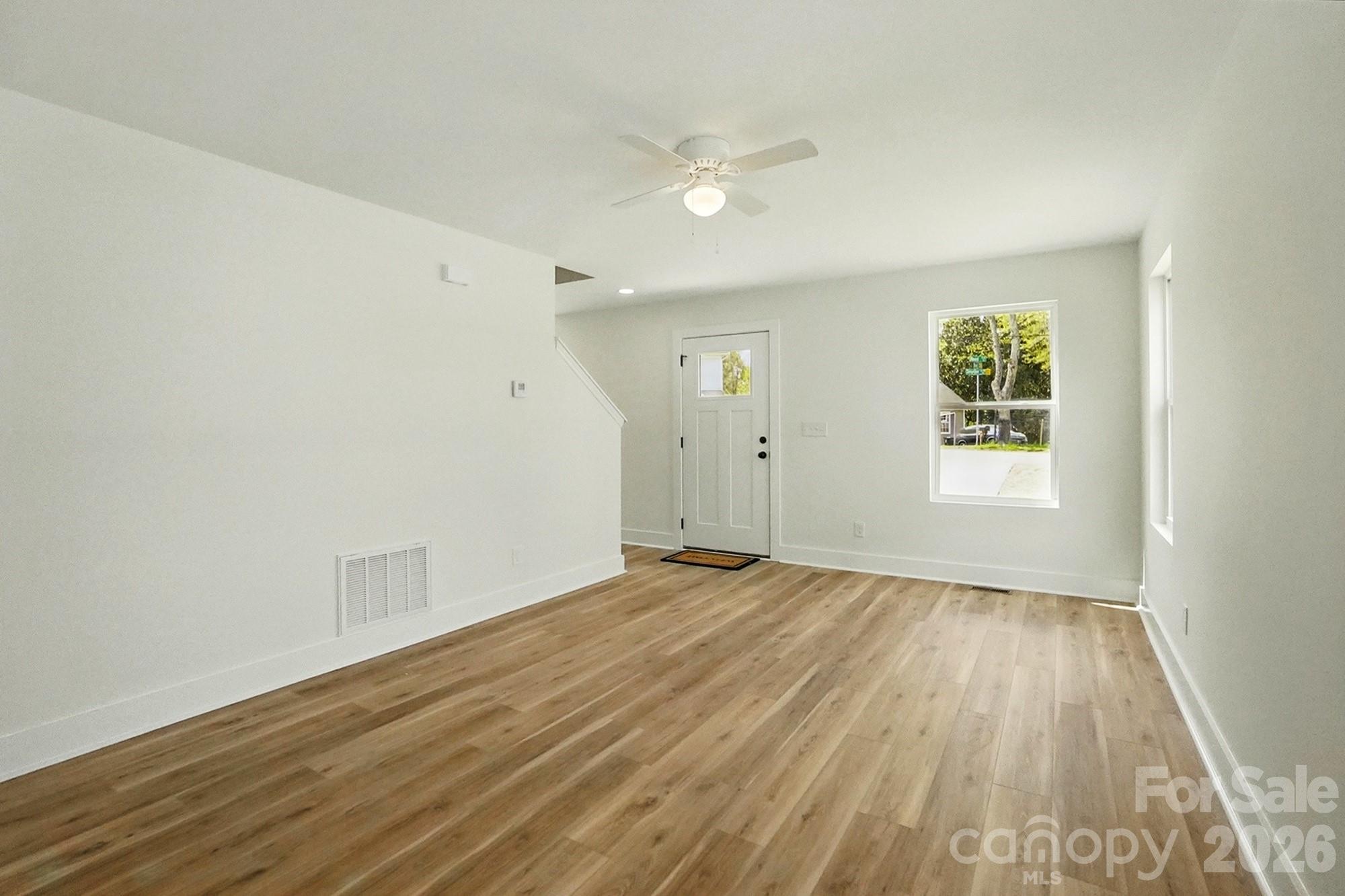 274 Bellhaven Place Northwest Concord, NC 28027 - Photo 5 of 27 an empty room with wooden floor and windows