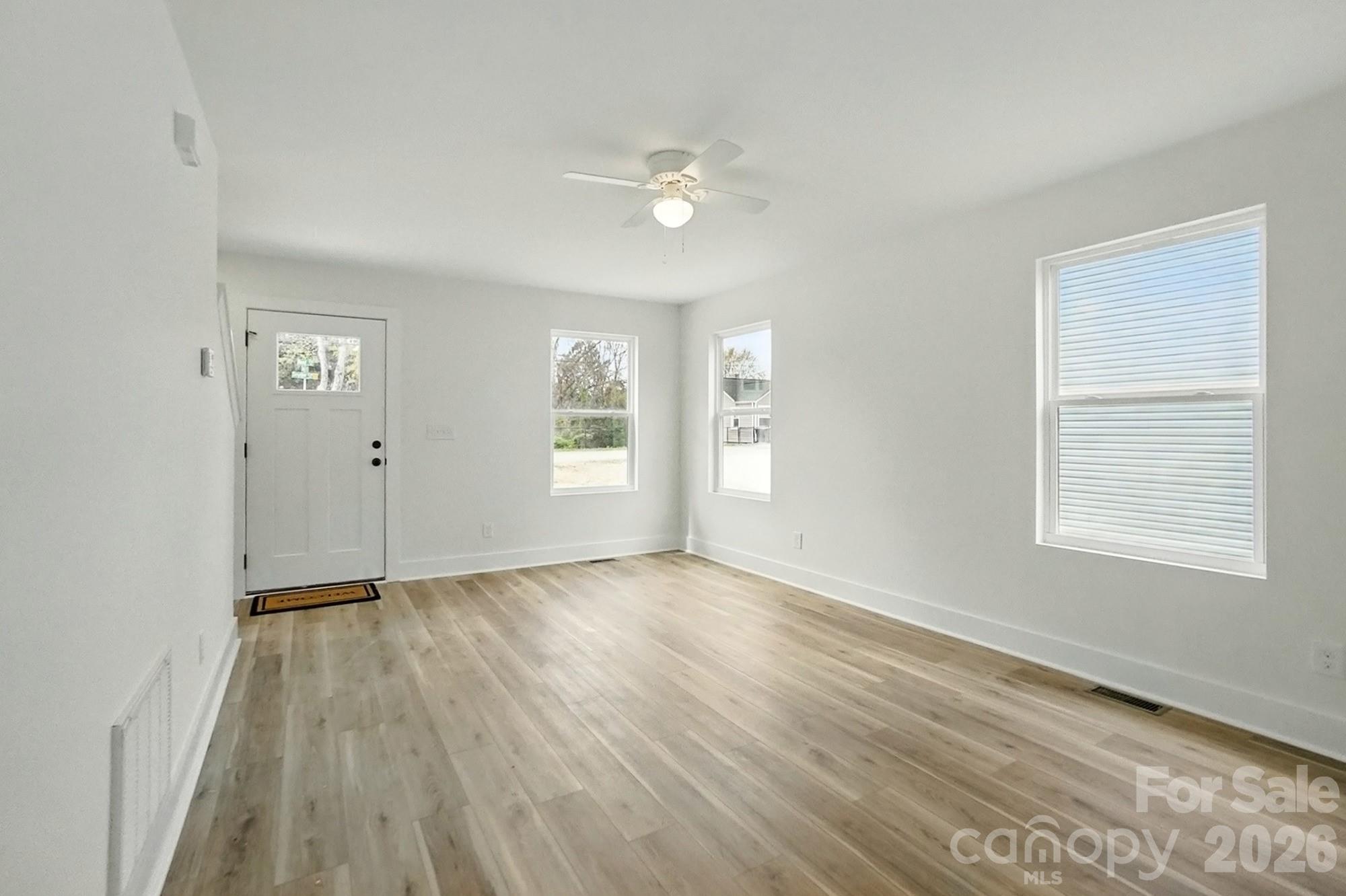 274 Bellhaven Place Northwest Concord, NC 28027 - Photo 6 of 27 a view of an empty room with wooden floor and a window