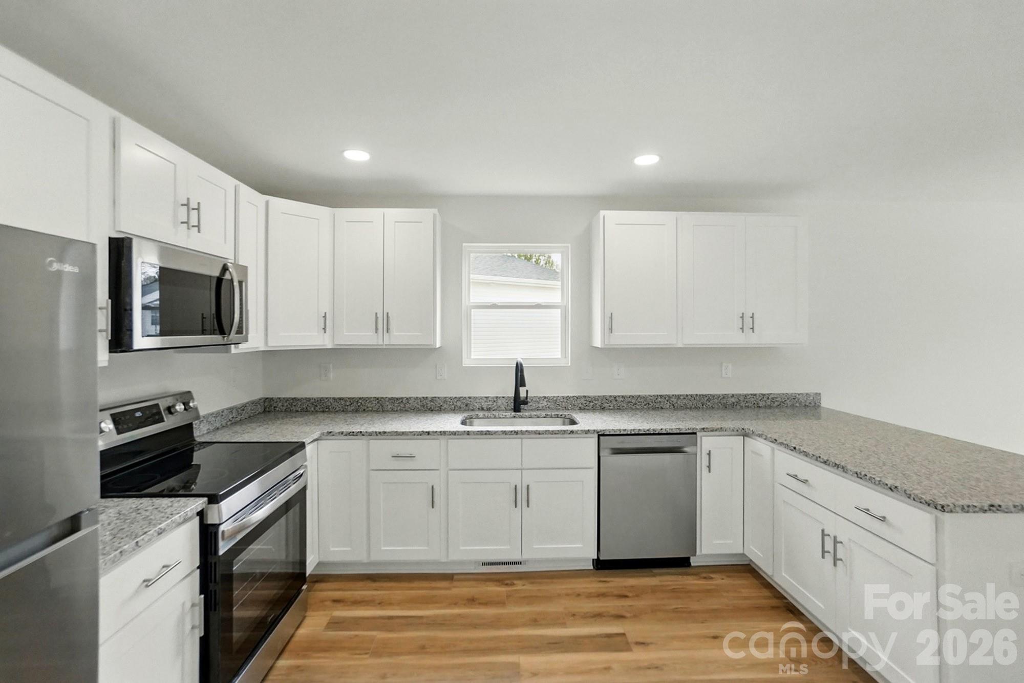 274 Bellhaven Place Northwest Concord, NC 28027 - Photo 7 of 27 a kitchen with a sink stove and cabinets