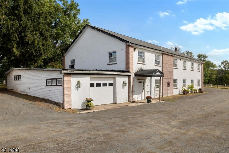1850 Burnt Mills Road Bedminster, NJ 07921 - Photo 11 of 30 a view of a white house with large windows and a road