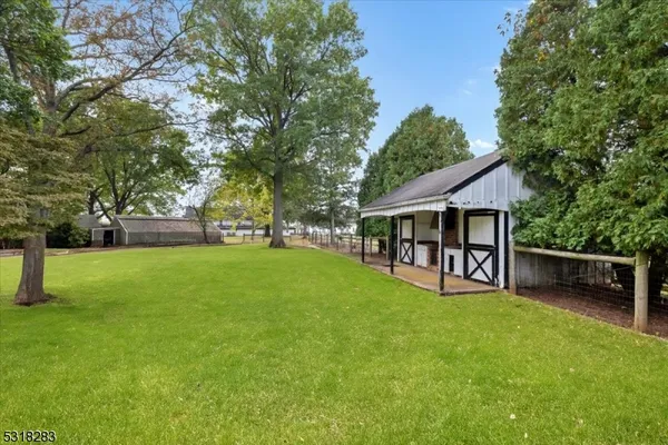 a view of a house with backyard and a tree