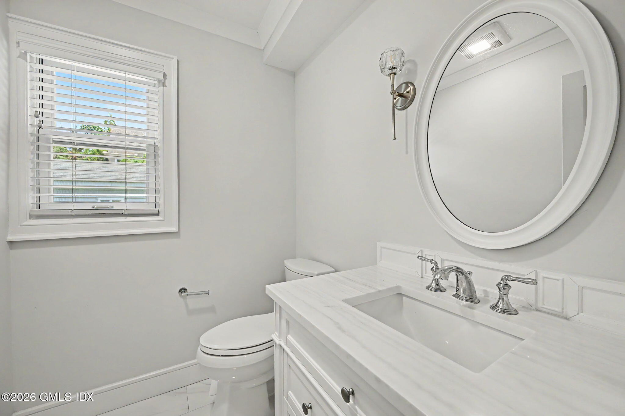 124 Shore Road Old Greenwich, CT 06870 - Photo 12 of 28 a bathroom with a sink a toilet and a mirror