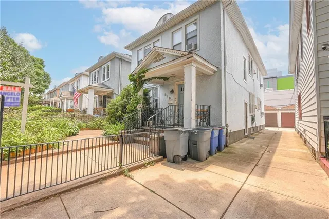 a view of a house with a floor to ceiling window and wooden fence