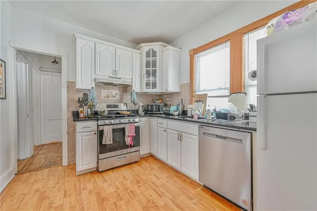 a kitchen with granite countertop white cabinets and white appliances