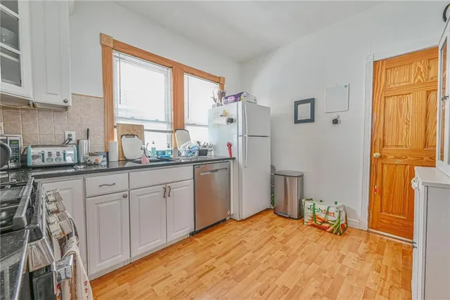 a kitchen with a refrigerator sink and cabinets