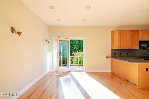 a view of a kitchen with wooden floor and a window