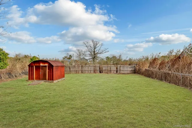 a big yard with table and chairs and a large tree