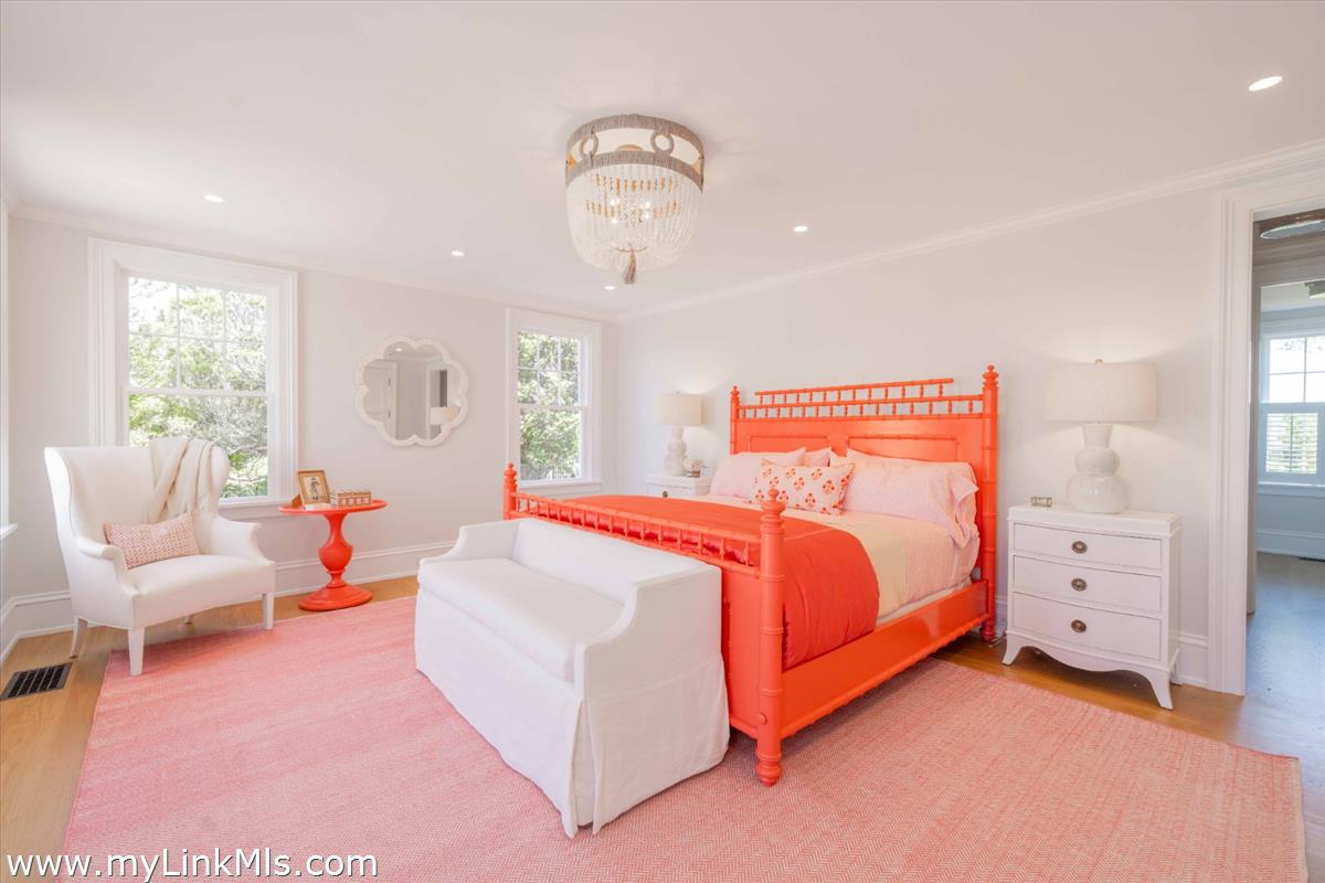 256 Polpis Road Nantucket, MA 02554 - Photo 11 of 30 a spacious bedroom with a bed and a chandelier