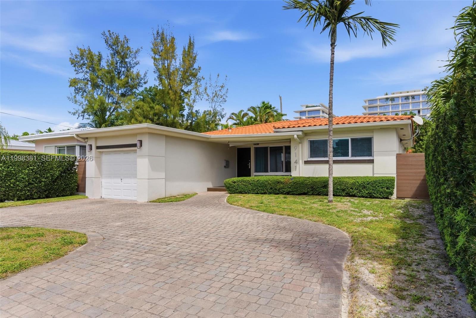 9141 Abbott Avenue Surfside, FL 33154 - Photo 24 of 31 a front view of house with yard and trees