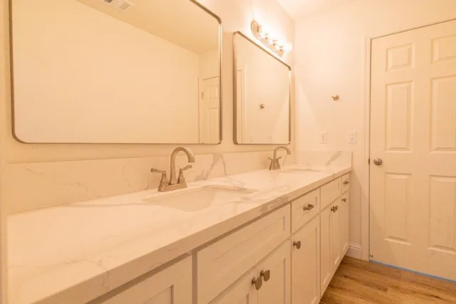 a bathroom with a double vanity sink and a mirror