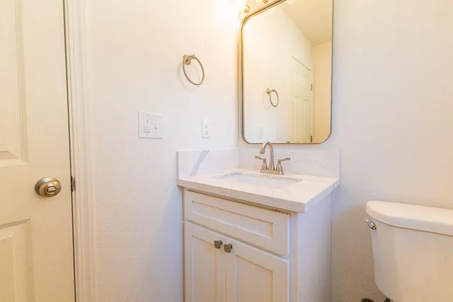 a bathroom with a sink a toilet and a mirror