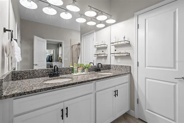 a view of a dining room and livingroom with furniture wooden floor a chandelier