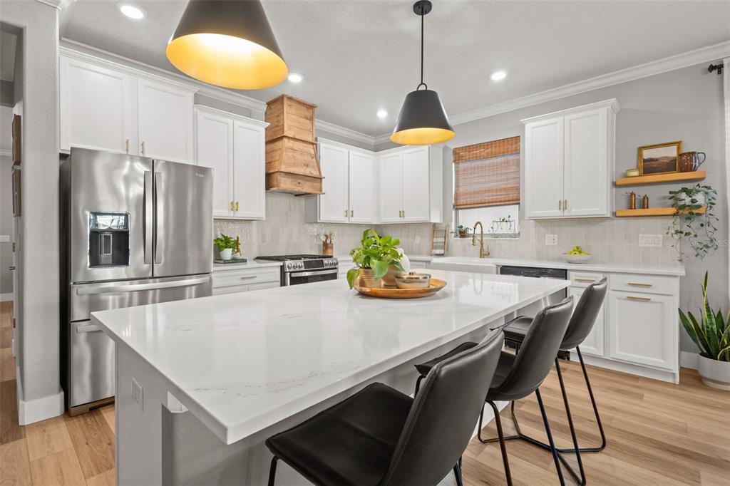 4465 Tubular Run Land O Lakes, FL 34638 - Photo 17 of 60 a kitchen with stainless steel appliances a table chairs and a refrigerator