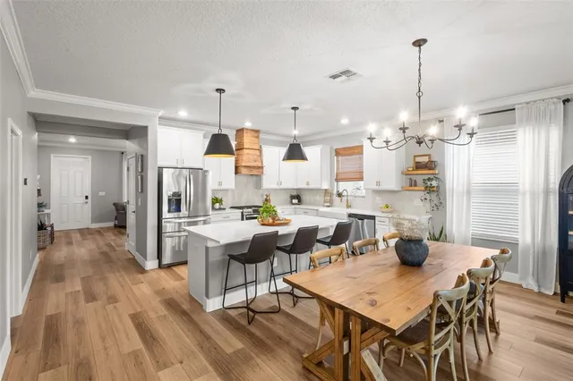 a kitchen with stainless steel appliances granite countertop a sink a stove and white cabinets
