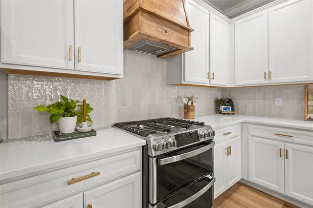 a kitchen with white cabinets and a wooden floor
