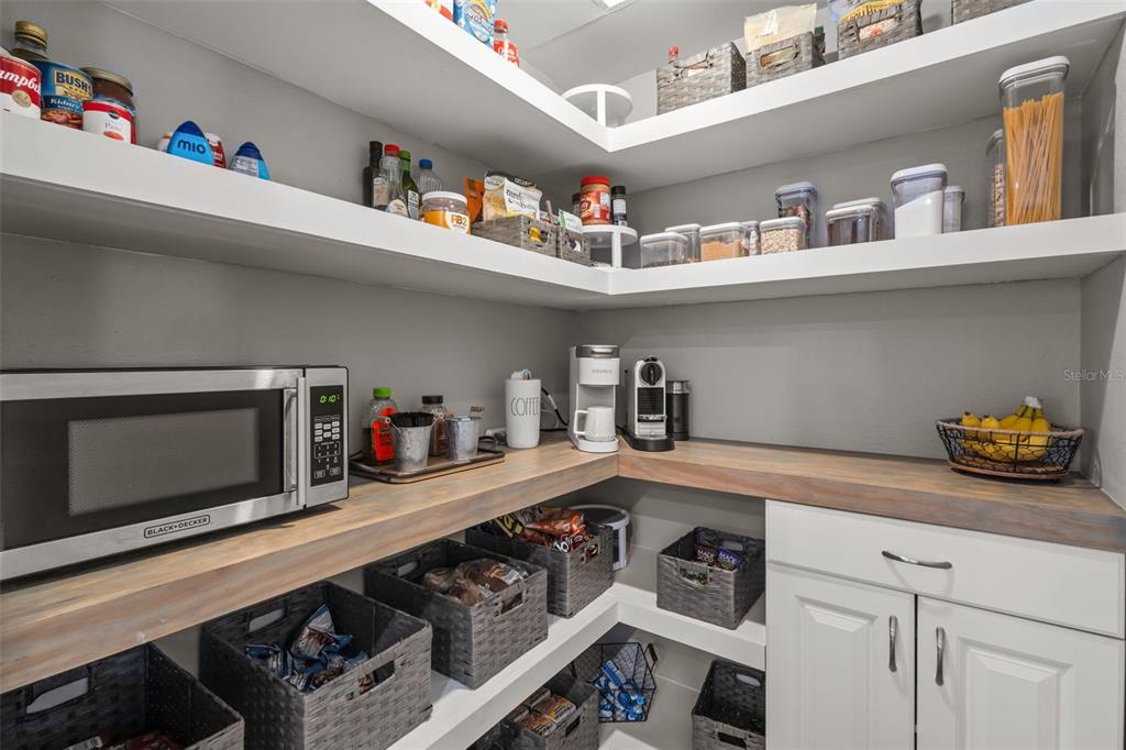 4465 Tubular Run Land O Lakes, FL 34638 - Photo 22 of 60 a kitchen with white cabinets and a wooden floor
