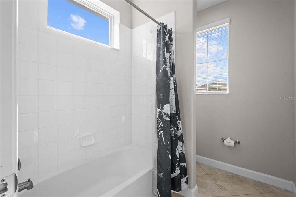 4465 Tubular Run Land O Lakes, FL 34638 - Photo 34 of 60 a bathroom with a shower curtain and a window