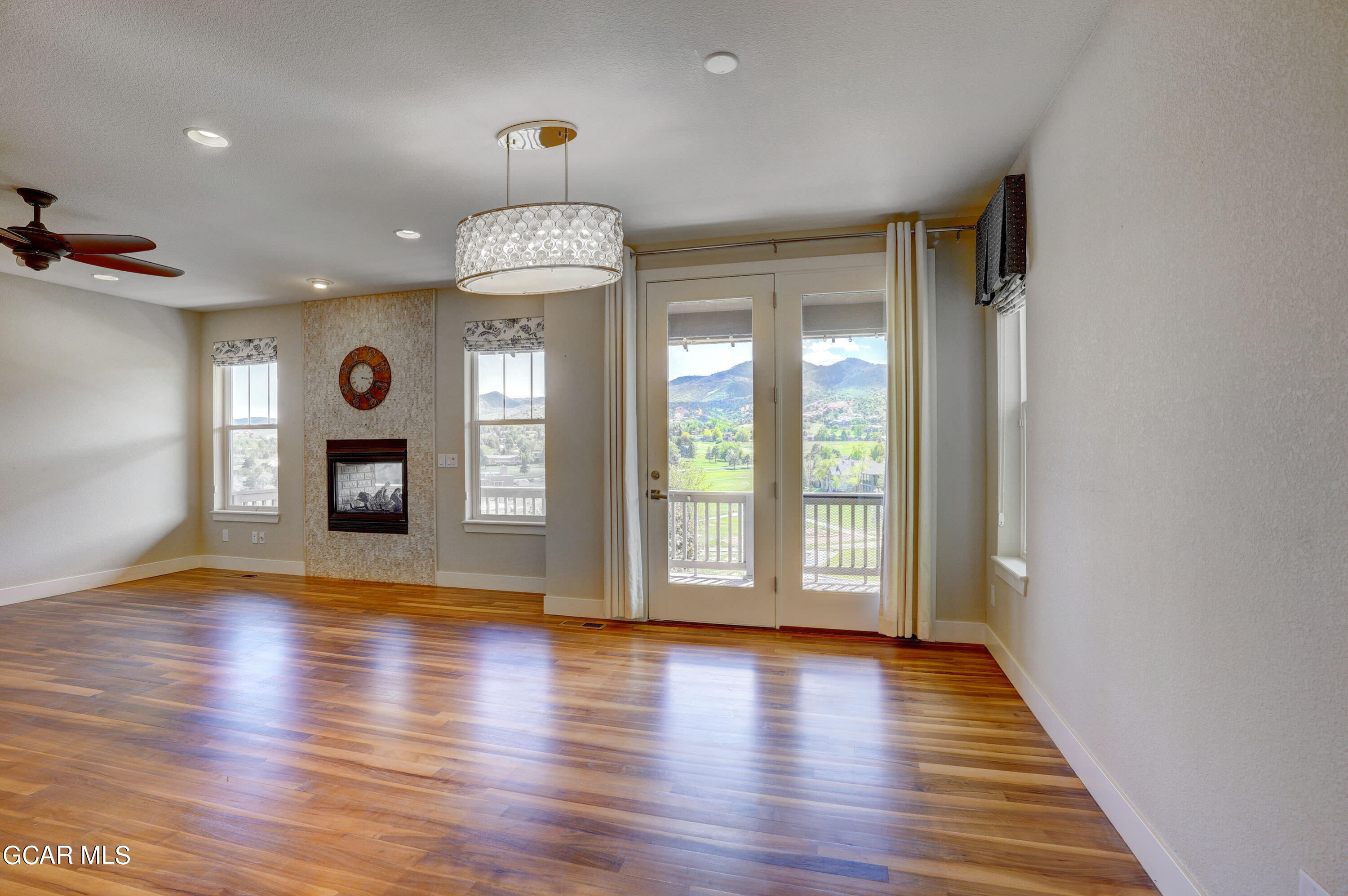 15526 Red Deer Drive Morrison, CO 80465 - Photo 30 of 82 an empty room with wooden floor chandelier and glass door