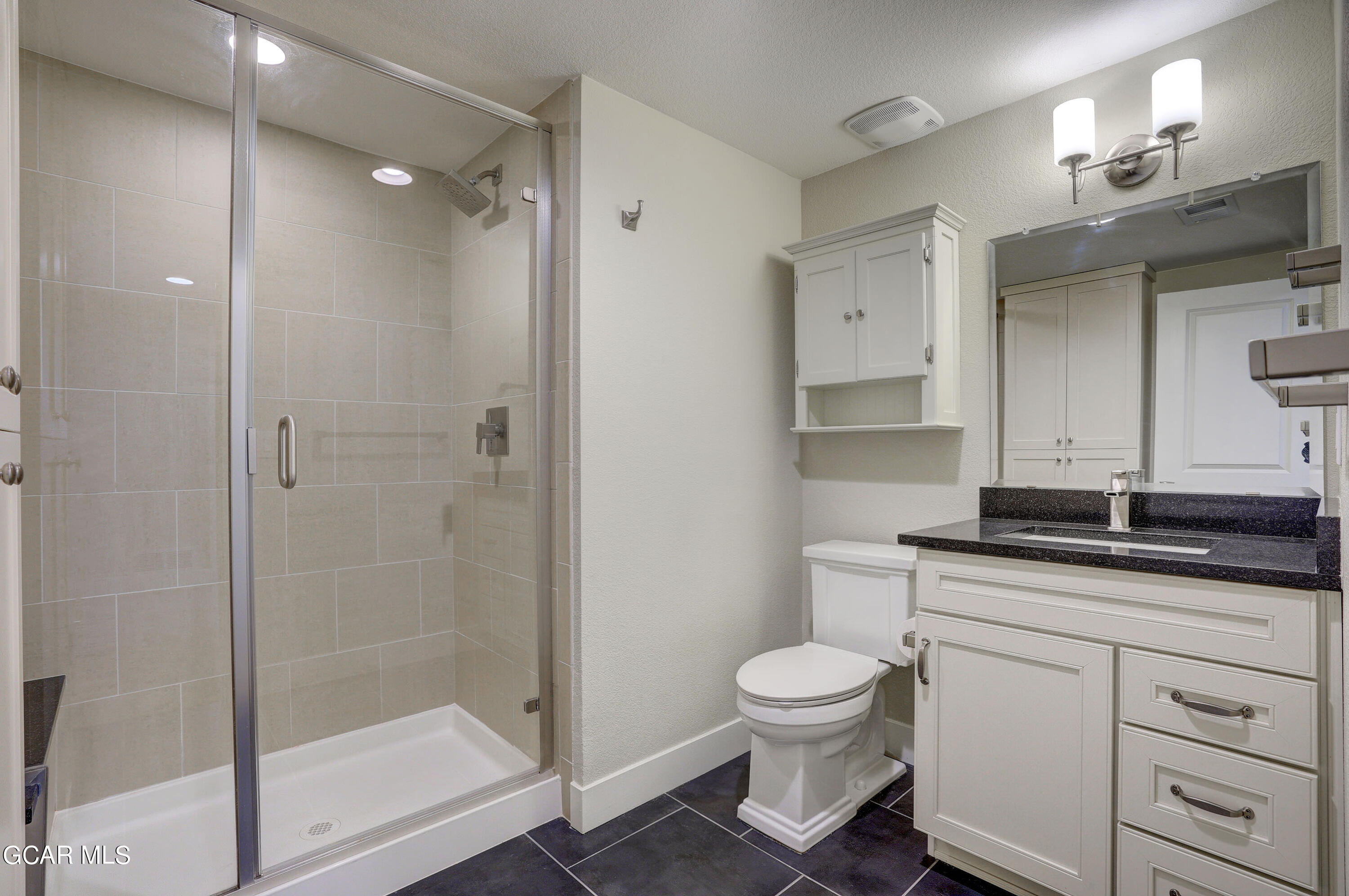 15526 Red Deer Drive Morrison, CO 80465 - Photo 52 of 82 a bathroom with a granite countertop toilet a sink and a mirror