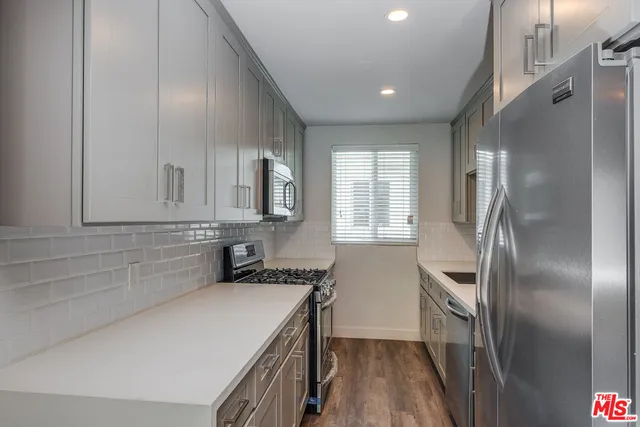 a kitchen with kitchen island a sink appliances and cabinets