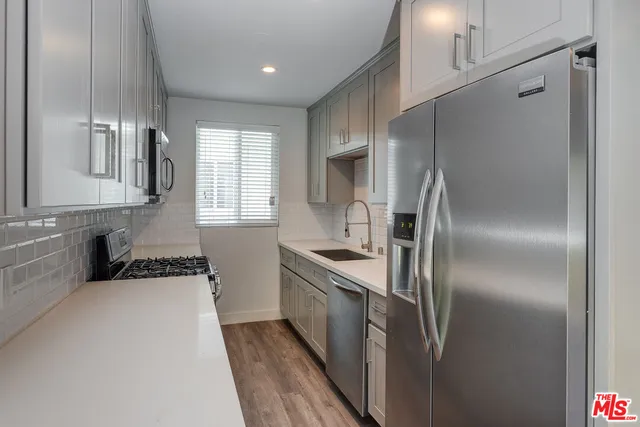 a kitchen with granite countertop a refrigerator and a sink