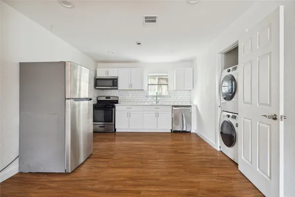 a kitchen with a refrigerator a washer and dryer