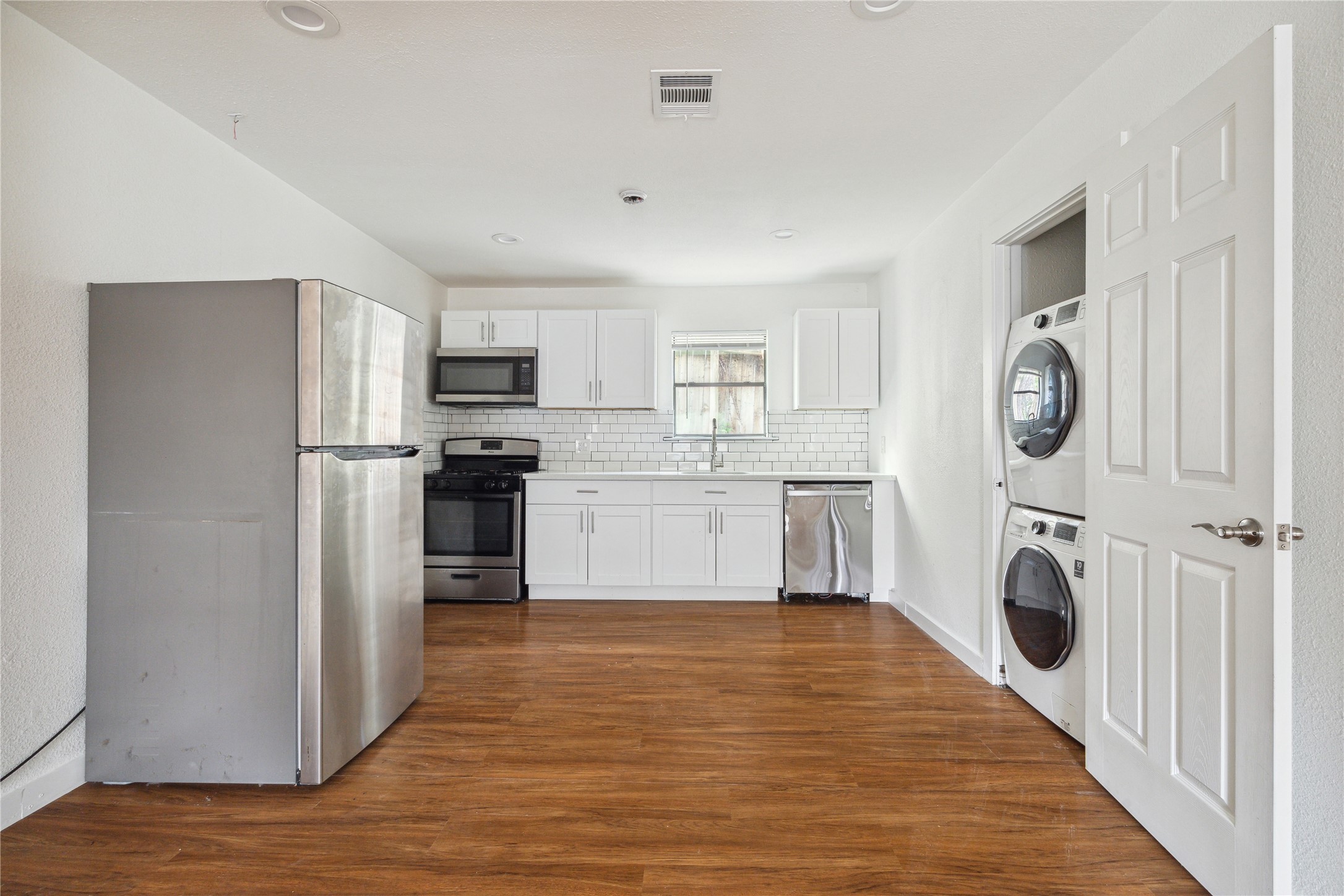 4210 Delhi Street, Unit 1/2 Houston, TX 77022 - Photo 4 of 8 a kitchen with a refrigerator a washer and dryer