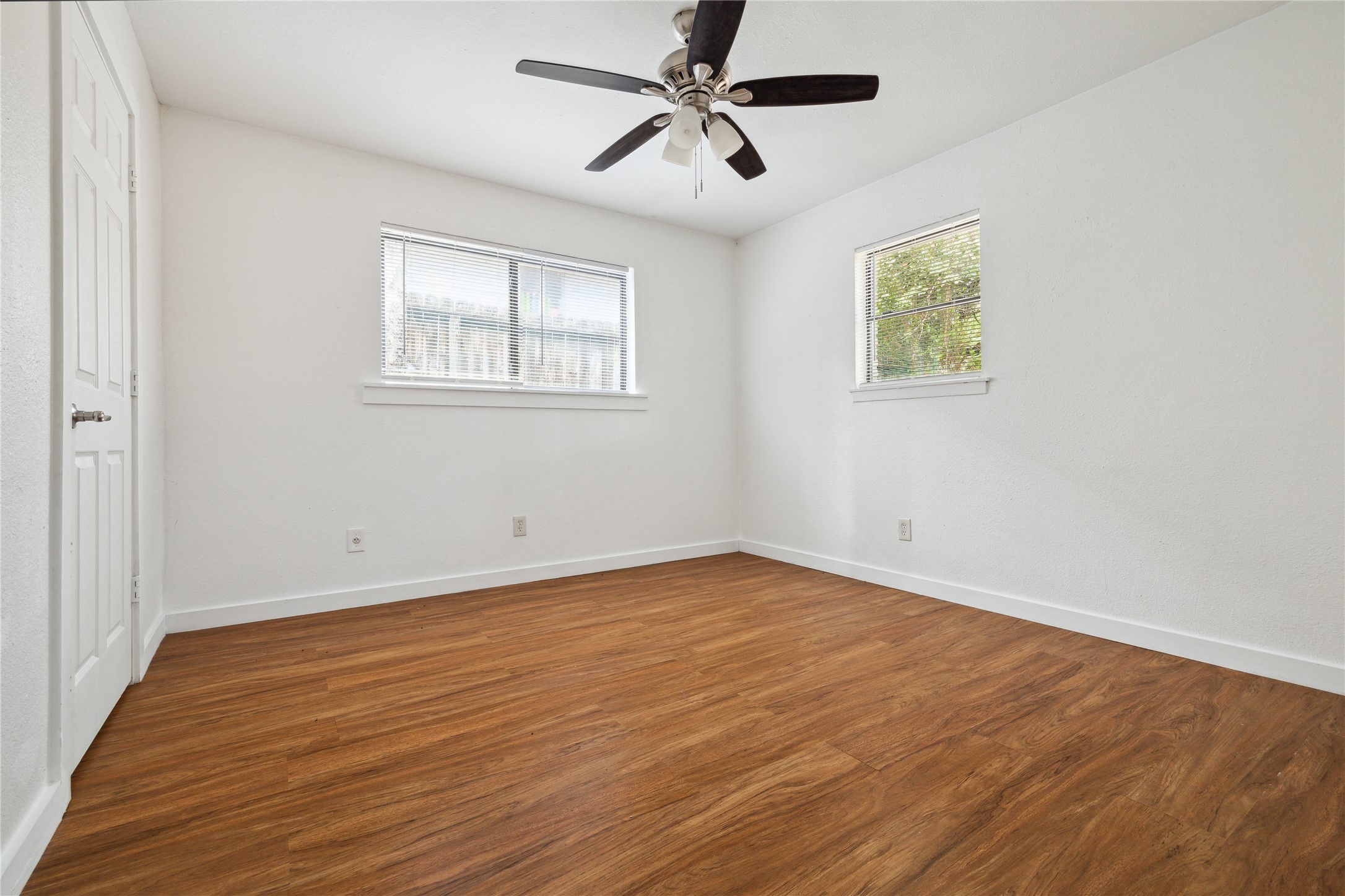 4210 Delhi Street, Unit 1/2 Houston, TX 77022 - Photo 7 of 8 an empty room with wooden floor ceiling fan and windows