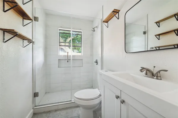 a bathroom with a sink toilet and shower