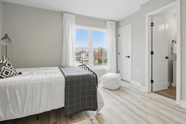 a bedroom with a beds and wooden floor