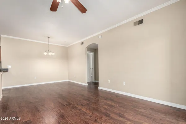 a view of an empty room with wooden floor and window