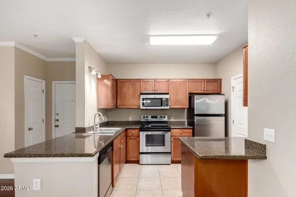 a kitchen with kitchen island granite countertop a sink stove and refrigerator