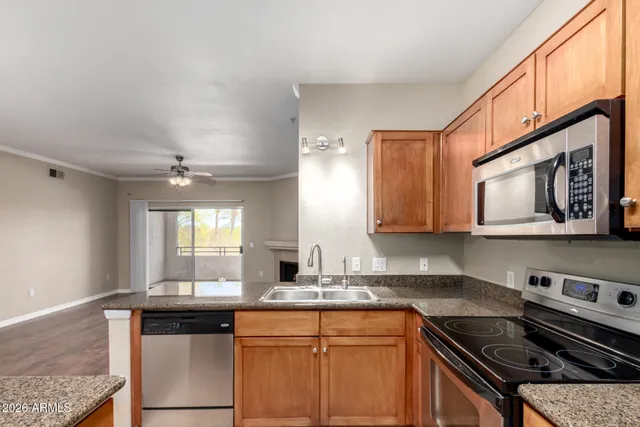 a kitchen with stainless steel appliances granite countertop a sink stove and cabinets