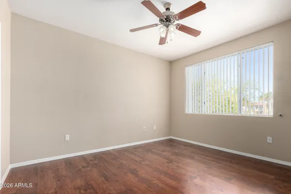 an empty room with a window and a fan