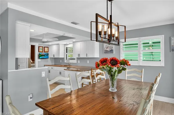 a dining room with furniture potted plants and wooden floor