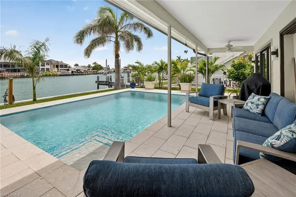 a view of swimming pool with outdoor seating and a patio