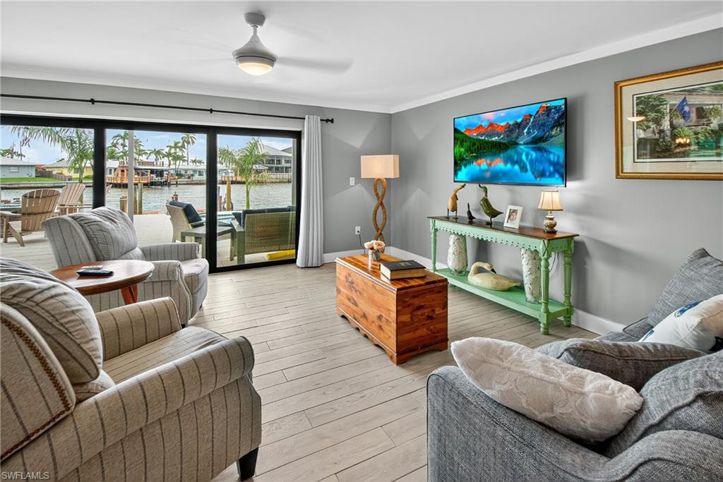 190 Tahiti Circle Naples, FL 34113 - Photo 6 of 32 a living room with furniture a flat screen tv and a large window