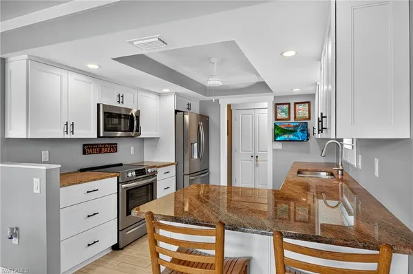 a kitchen with kitchen island white cabinets and stainless steel appliances